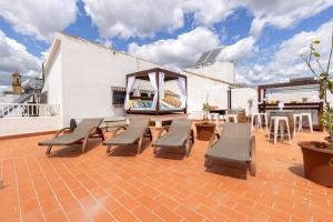 a patio with benches and tables on a roof at La Casa de Manuel in Estepona