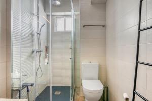 a bathroom with a toilet and a glass shower at Apartamento de playa en Cullera in Cullera +12 photos