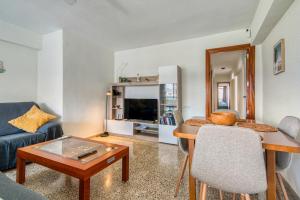 a living room with a blue couch and a table at Apartamento de playa en Cullera in Cullera