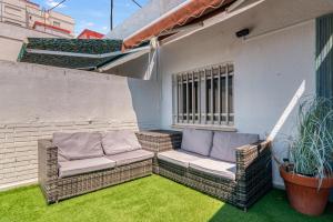 a patio with wicker furniture on the grass at Apartamento de playa en Cullera in Cullera
