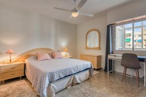 a bedroom with a bed and a desk and a window at Apartamento de playa en Cullera in Cullera