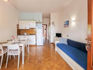 a living room with a blue couch and a kitchen at Casa Golfi di Lacona in Lacona