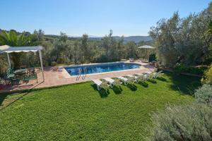 a swimming pool in a yard with a bunch of chairs at Casa Ginés in Iznájar