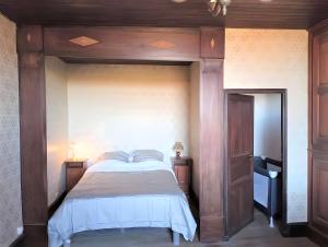 a bedroom with a large bed with a wooden headboard at La Maison Chez Karen in Séniergues