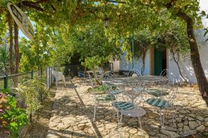 a patio with tables and chairs under a tree at Casa Ginés in Iznájar