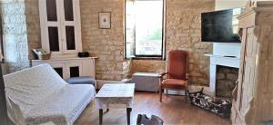 a living room with a couch and a fireplace at La Maison Chez Karen in Séniergues
