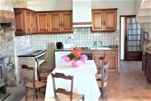 a kitchen with a table with flowers on it at La Maison Chez Karen in Séniergues