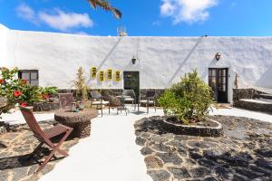 a building with chairs and tables in front of it at La Guajira in Güime