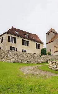 an old house with a stone wall and a building at La Maison Chez Karen in Séniergues