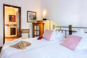 a bedroom with a white bed with pink and white pillows at La Guajira in Güime