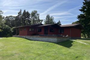 a red house with a grassy yard in front of it at Ferienhaus Vossberg in Grabow