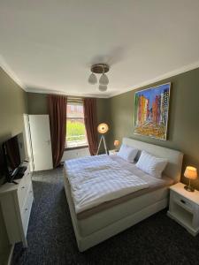 a bedroom with a white bed and a window at Stylischer Altbau im Zentrum in Kiel