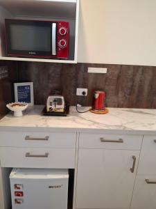 a kitchen counter with a toaster and a microwave at Studio Hugoway Papamoa Beach Winter Special in Papamoa +14 photos