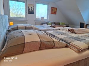 two large beds in a room with two windows at Ferienunterkunft Schrichten in Schmallenberg