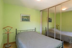 a bedroom with two beds and a mirror at Appartement N°2 - Piscine Partagée in Lagorce +15 photos