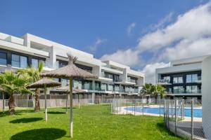 an external view of a resort with umbrellas and a swimming pool at Casa África in Zahara de los Atunes