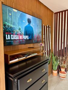 a flat screen tv sitting on top of a entertainment center at EcoStay Lençóis - apartamento in Lençóis
