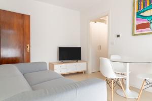 a living room with a couch and a tv and a table at Baseventuno 3 bilocale piano terra in Sirmione