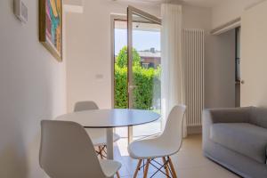 a living room with a table and chairs and a couch at Baseventuno 3 bilocale piano terra in Sirmione