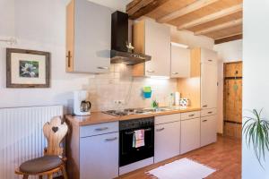 a kitchen with white cabinets and a stove top oven at Moserhof Ferienwohnung Schartblick in Sarntal