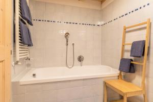 a bathroom with a white tub and a shower at Moserhof Ferienwohnung Schartblick in Sarntal +22 photos