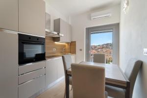 a kitchen with a dining room table with chairs and a window at Casa A Prima Vista Varazze in Varazze +17 photos