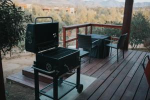 a grill on a deck with a table and chairs at 7 Valles in Valle de Guadalupe
