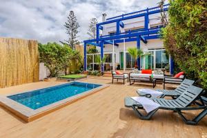a backyard with a swimming pool and a house at Villa with pool and beach access in Ben Slimane