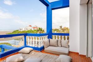 a balcony with a couch and a view of the ocean at Villa with pool and beach access in Ben Slimane