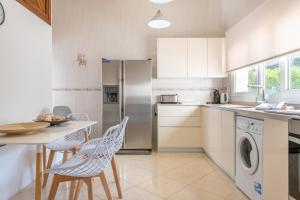 a kitchen with a table and chairs and a refrigerator at Villa Luca in Cala d´Or