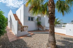 a palm tree in front of a white house at Villa Luca in Cala d´Or