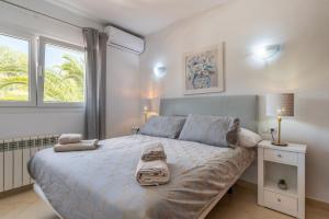 a bedroom with a large bed with towels on it at Villa Luca in Cala d´Or +17 photos