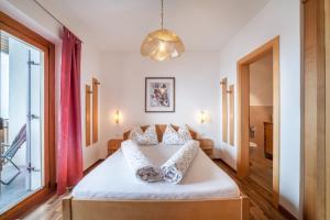 a bedroom with a bed and a large window at Haus Hohenrain Ferienwohnung 3 in Schenna +19 photos