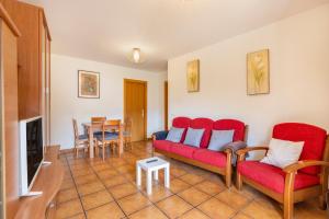 a living room with a red couch and a table at Apartament Garrota in Olp