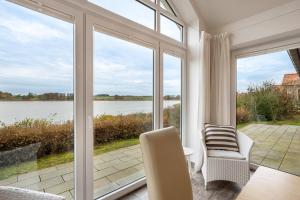 a living room with large windows and a view of the water at Schwanenuferhaus in Kosel