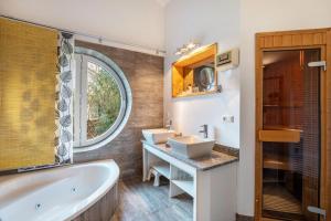 a bathroom with two sinks and a tub and a window at Schwanenuferhaus in Kosel +28 photos