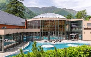 an exterior view of a building with a swimming pool at L'Izard Piscine, Jacuzzi, Parking in Cauterets