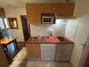 a small kitchen with a sink and a microwave at L'Izard Piscine, Jacuzzi, Parking in Cauterets