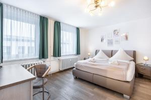 a hotel room with a bed and a desk at Pension Clara in Klipphausen