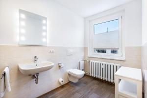a bathroom with a sink and a toilet and a window at Pension Clara in Klipphausen +51 photos