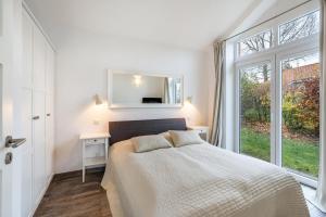 a bedroom with a bed with a mirror and a window at Schwanenuferhaus in Kosel