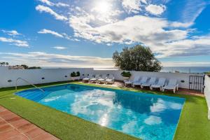 a swimming pool on top of a building with chairs at Casa Green in Mijas Costa