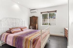 a white bedroom with a bed and a window at Casa Green in Mijas Costa +13 photos