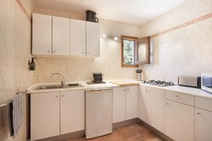 a small kitchen with white cabinets and a sink at Can Mussenya 2 in Illes Balears +19 photos