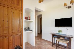 a living room with a tv on a wall with a table at Can Mussenya 2 in Illes Balears