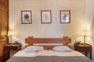a bedroom with a bed and three pictures on the wall at Can Mussenya 2 in Illes Balears