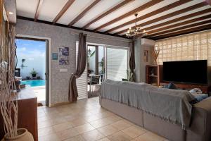 a living room with a couch and a tv at Villa Fae in Playa Blanca