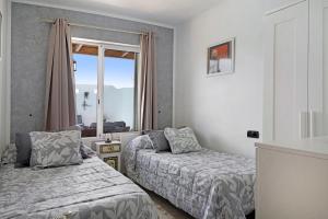 a bedroom with two beds and a window at Villa Fae in Playa Blanca +23 photos