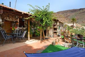 a patio with a table and chairs and a house at Casa Los Pinos in Agüimes