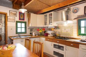 a kitchen with white cabinets and a table with a bowl of fruit at Casa Los Pinos in Agüimes